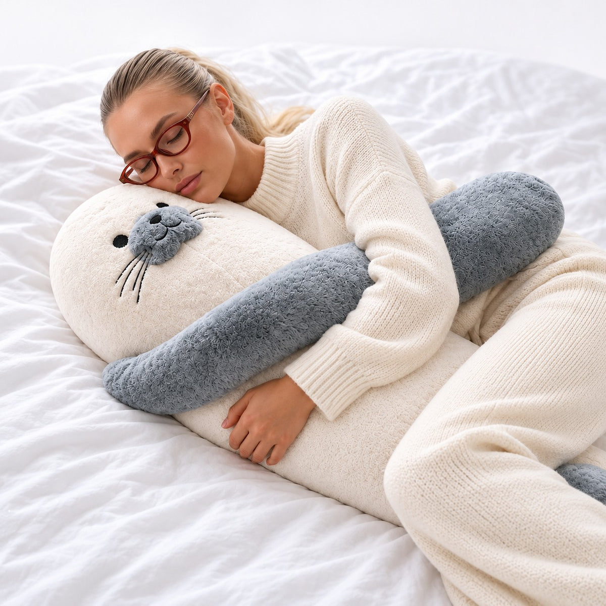 Woman sleeping while hugging Sully the Seal